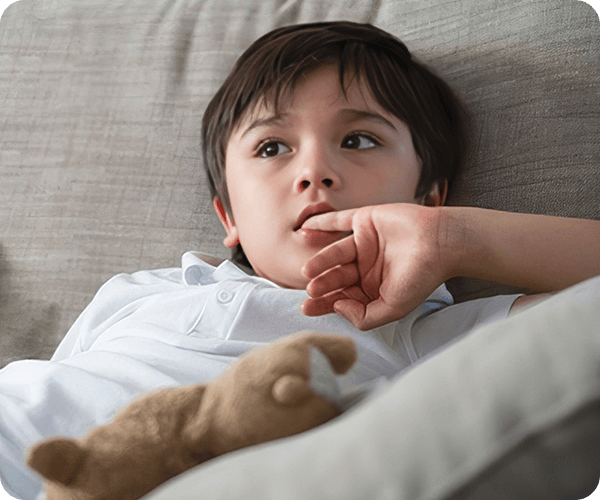 A boy laying on the couch with his arm resting on his chest.