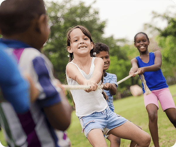 A group of kids playing tug-o-war with ropes.