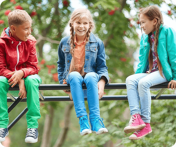 Three children sitting on a bench in the park.